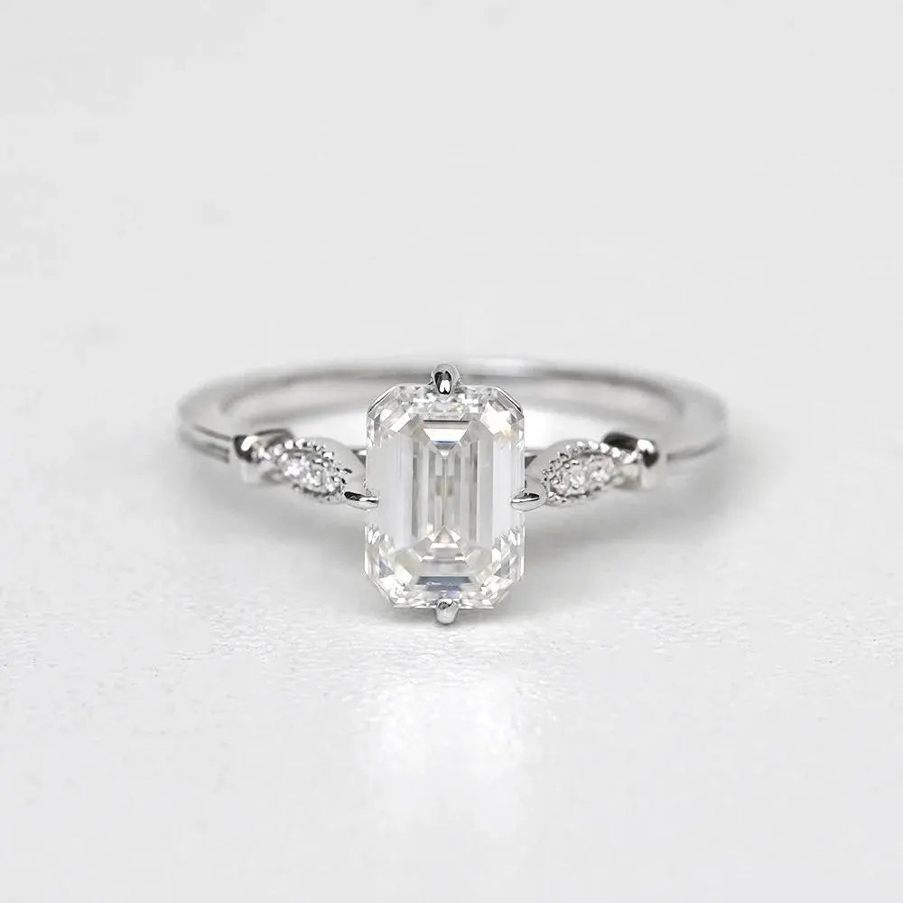 Elegant Emerald Cut Solitaire Engagement Ring In White Gold With Dainty Accent Stones. A Timeless Moissanite Wedding Or Promise Ring For Her