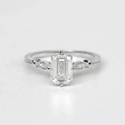 Elegant Emerald Cut Solitaire Engagement Ring In White Gold With Dainty Accent Stones. A Timeless Moissanite Wedding Or Promise Ring For Her
