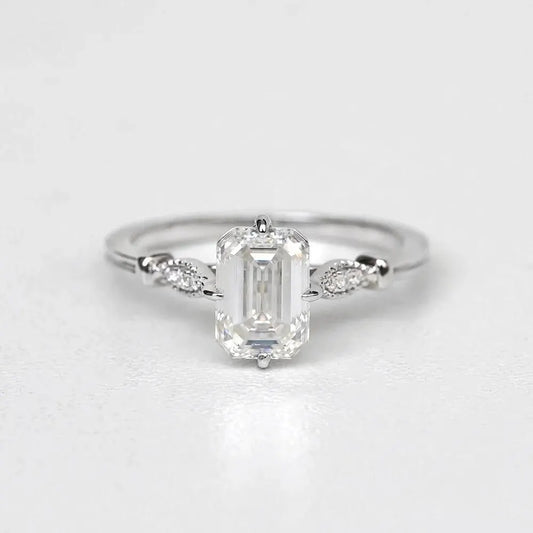Elegant Emerald Cut Solitaire Engagement Ring In White Gold With Dainty Accent Stones. A Timeless Moissanite Wedding Or Promise Ring For Her