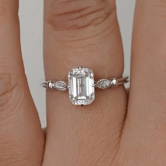 Elegant Emerald Cut Solitaire Engagement Ring In White Gold With Dainty Accent Stones. A Timeless Moissanite Wedding Or Promise Ring For Her
